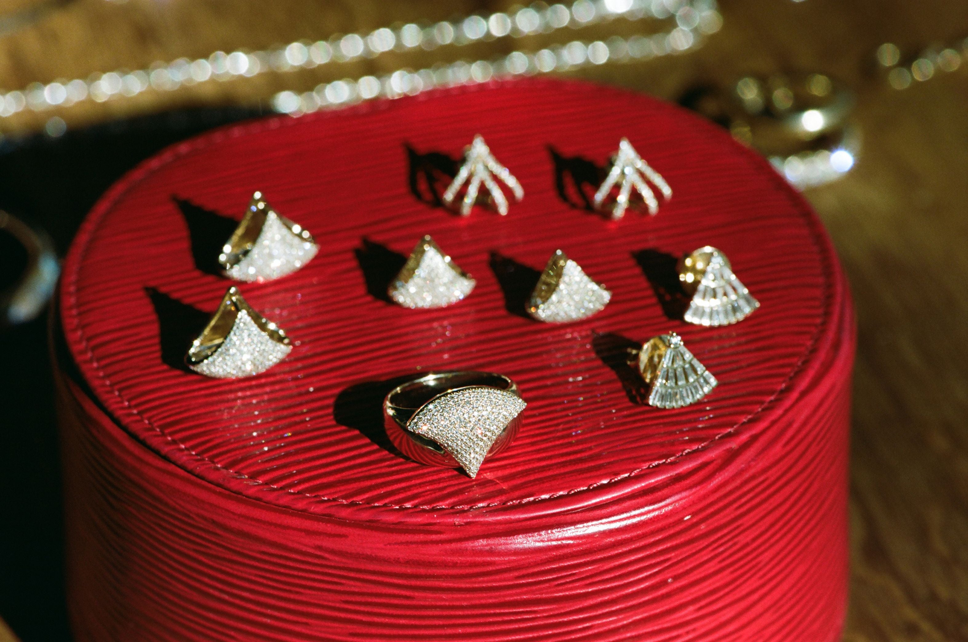 Red jewelry box with gold and silver earrings on a blurred background