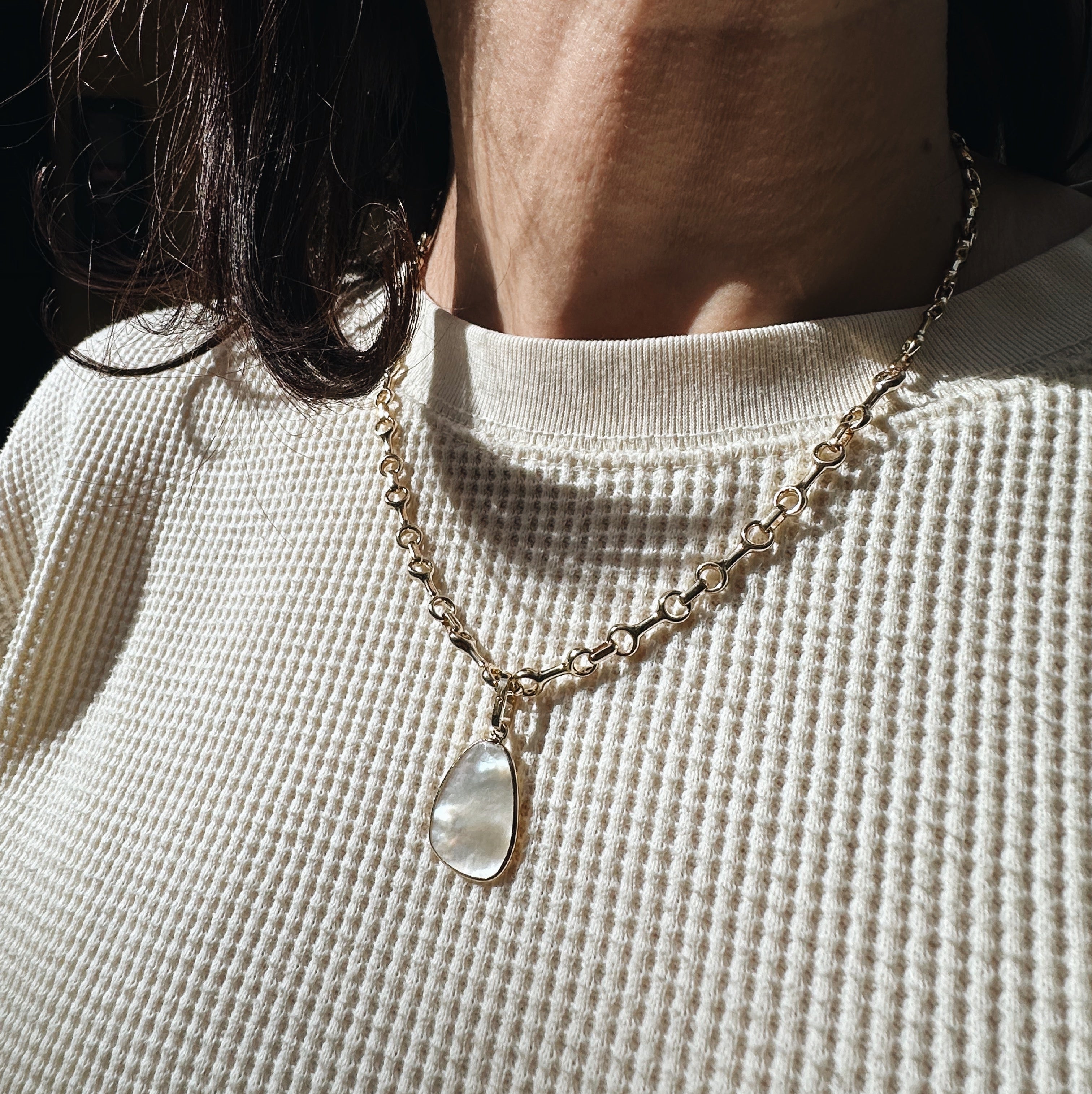 This mother of pearl drop pendant, elegantly set in a 14K yellow gold frame, is designed to complement most chains, offering a timeless and versatile addition to any jewelry collection - Gabriela Artigas