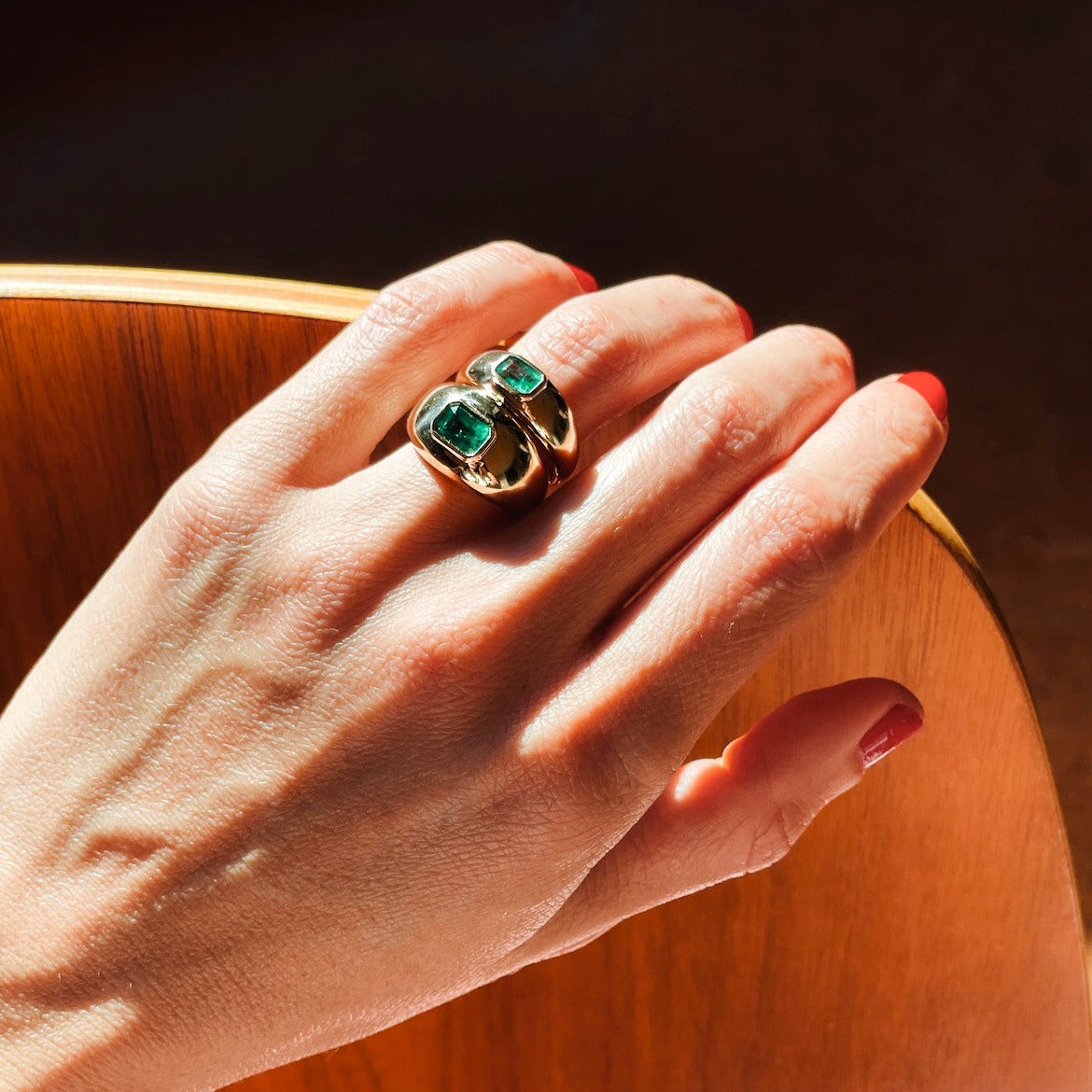 A girl elegantly showcasing a double balloon ring with vibrant emeralds- Gabriela Artigas