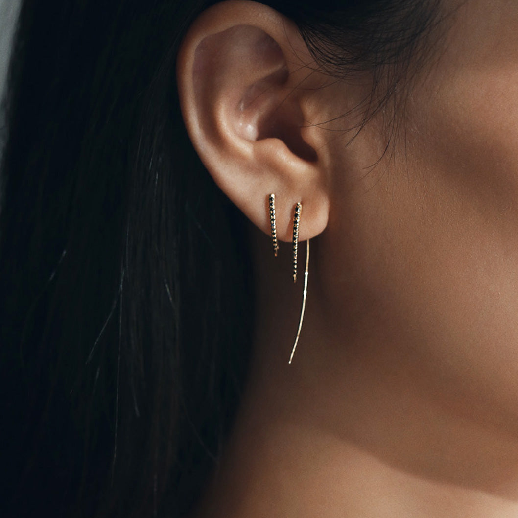 Black pave Diamonds gleam on this 14K yellow gold XL Infinite Tusk Earring, a bold statement earring designed for unmatched modern elegance - Gabriela Artigas