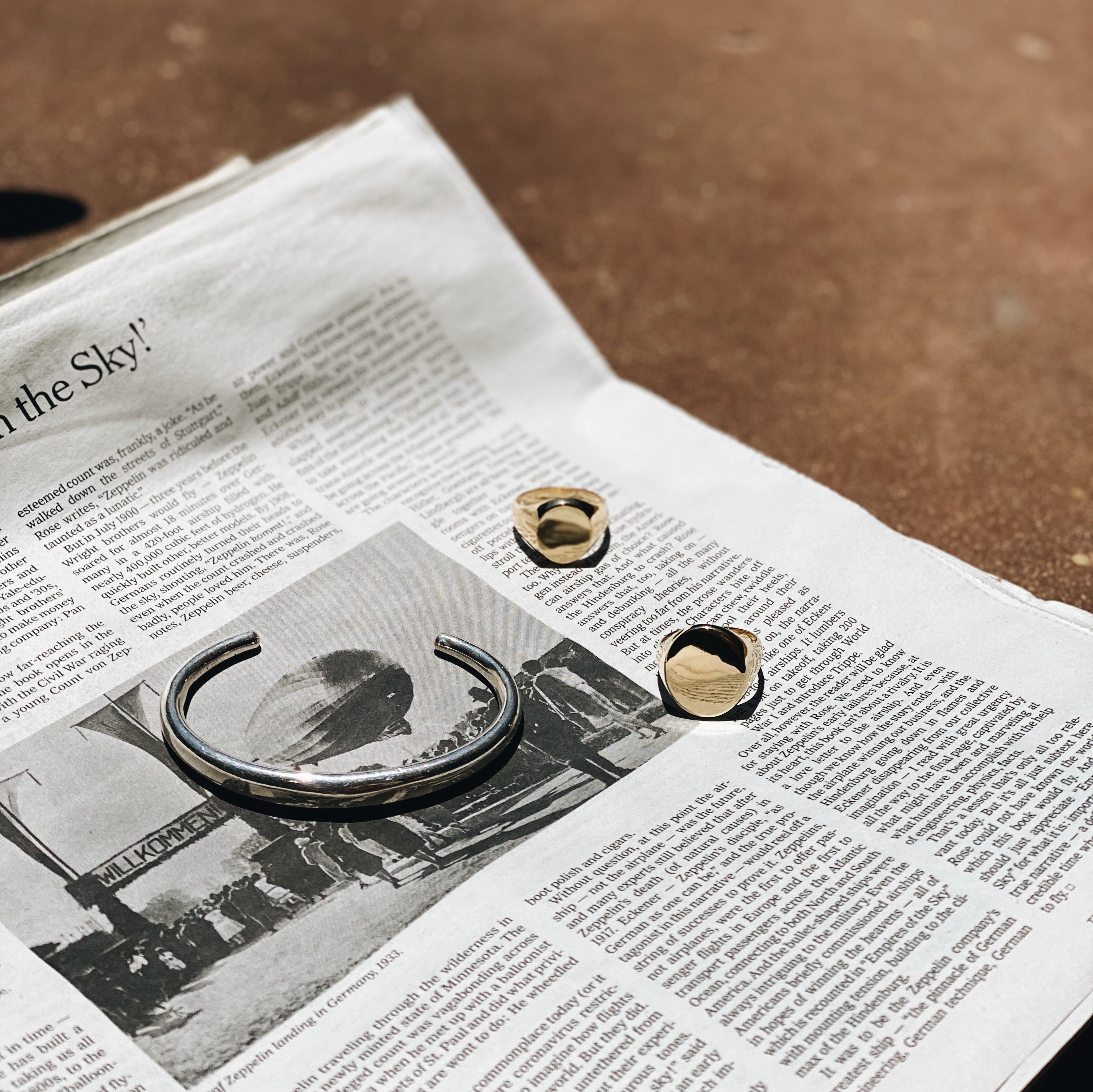 Beam cuff in sterling silver elegantly displayed on a newspaper - Gabriela Artigas